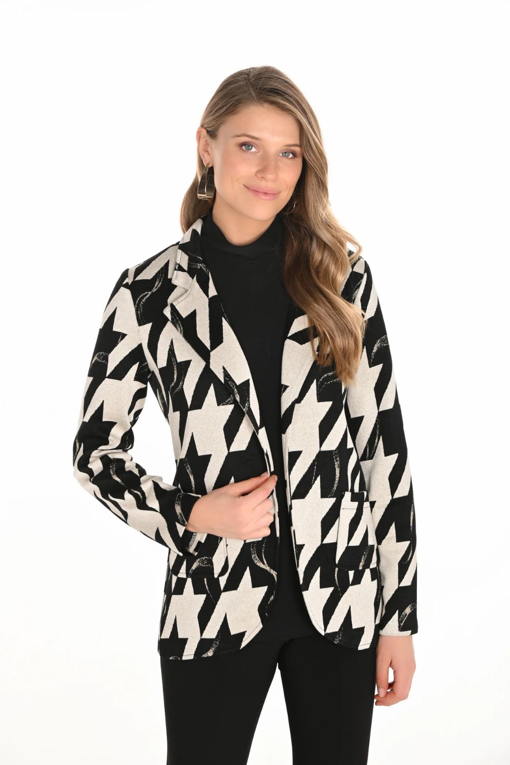 Woman wearing a black and white patterned jacket on a white background
